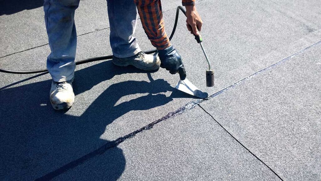 A homeowner inspects their residential shingle roof for signs of damage after a heavy winter storm.