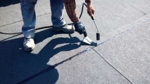 A homeowner inspects their residential shingle roof for signs of damage after a heavy winter storm.