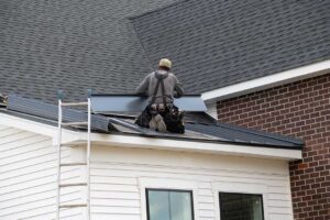 Homeowner inspecting gutters and roof edges beside a leaf-covered house in autumn